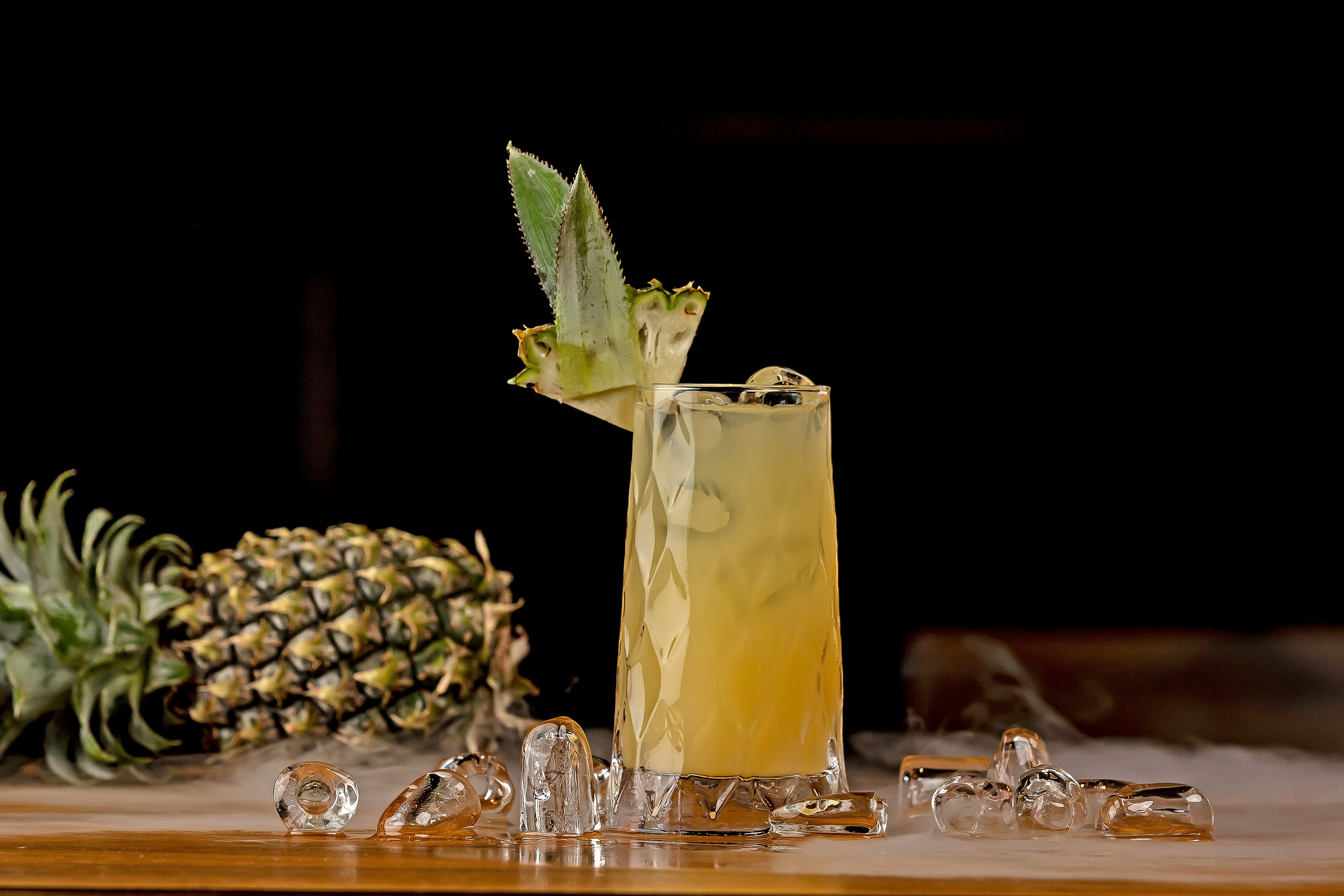 A pineapple drink with a pineapple in the background, highlighting fruity mocktail alternatives as enjoyable, alcohol-free options for those with alcohol intolerance.