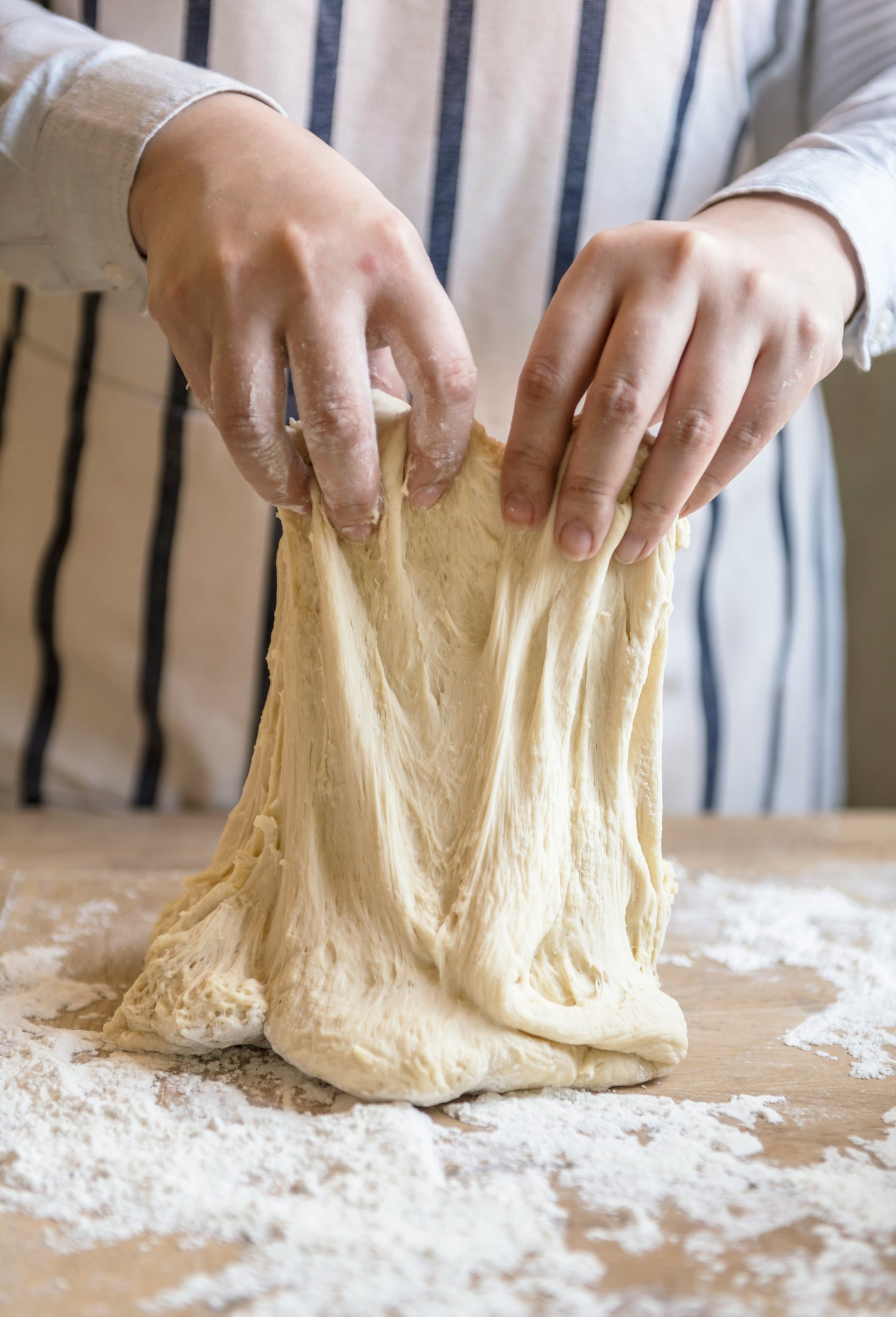 Pizza dough being prepared, showcasing gluten-rich foods that may need to be avoided by those managing gluten intolerance.