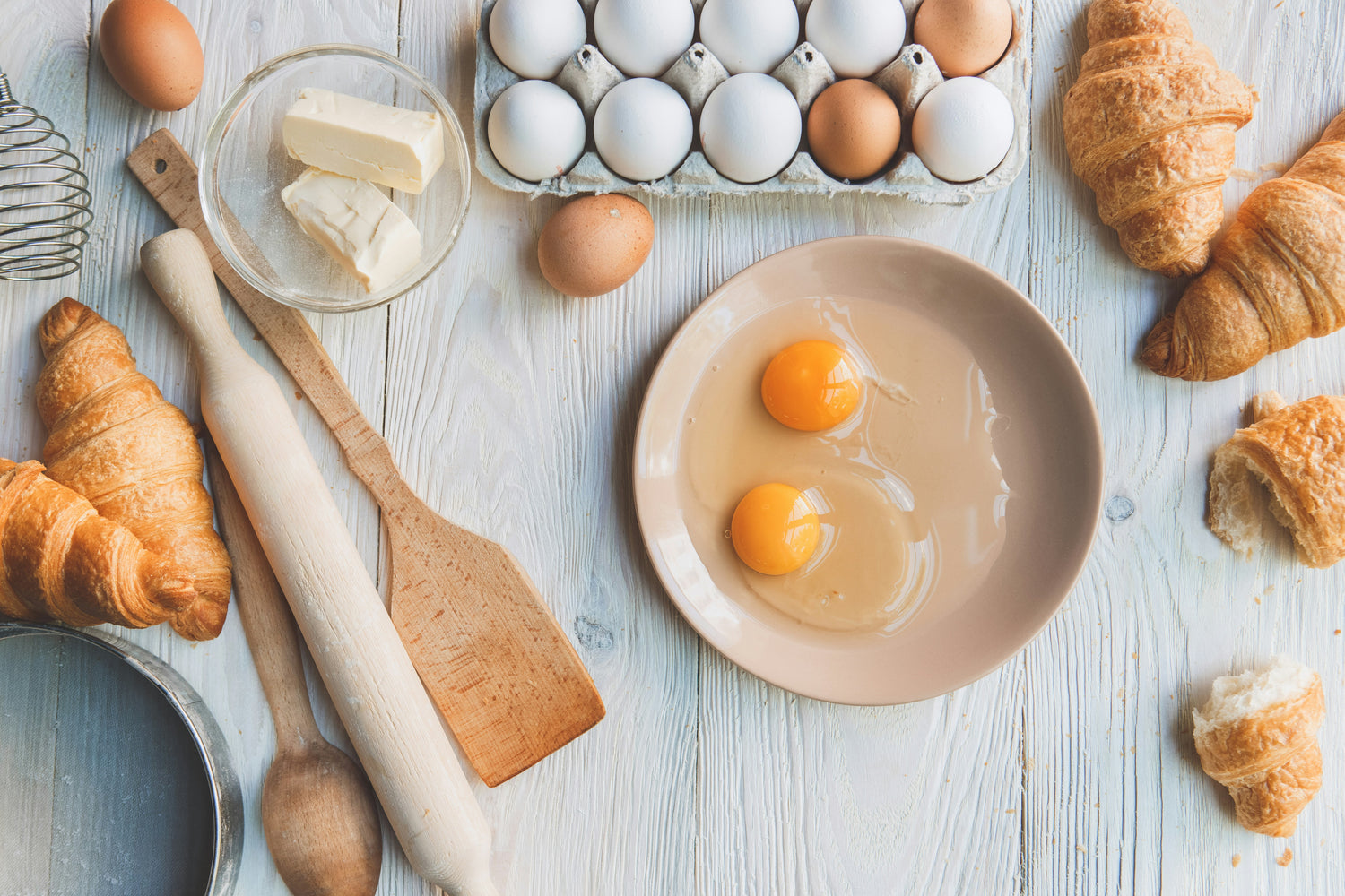 An assortment of baking ingredients, including flour and eggs, demonstrating the prevalence of eggs in recipes and the need for egg-free alternatives for those with intolerance.