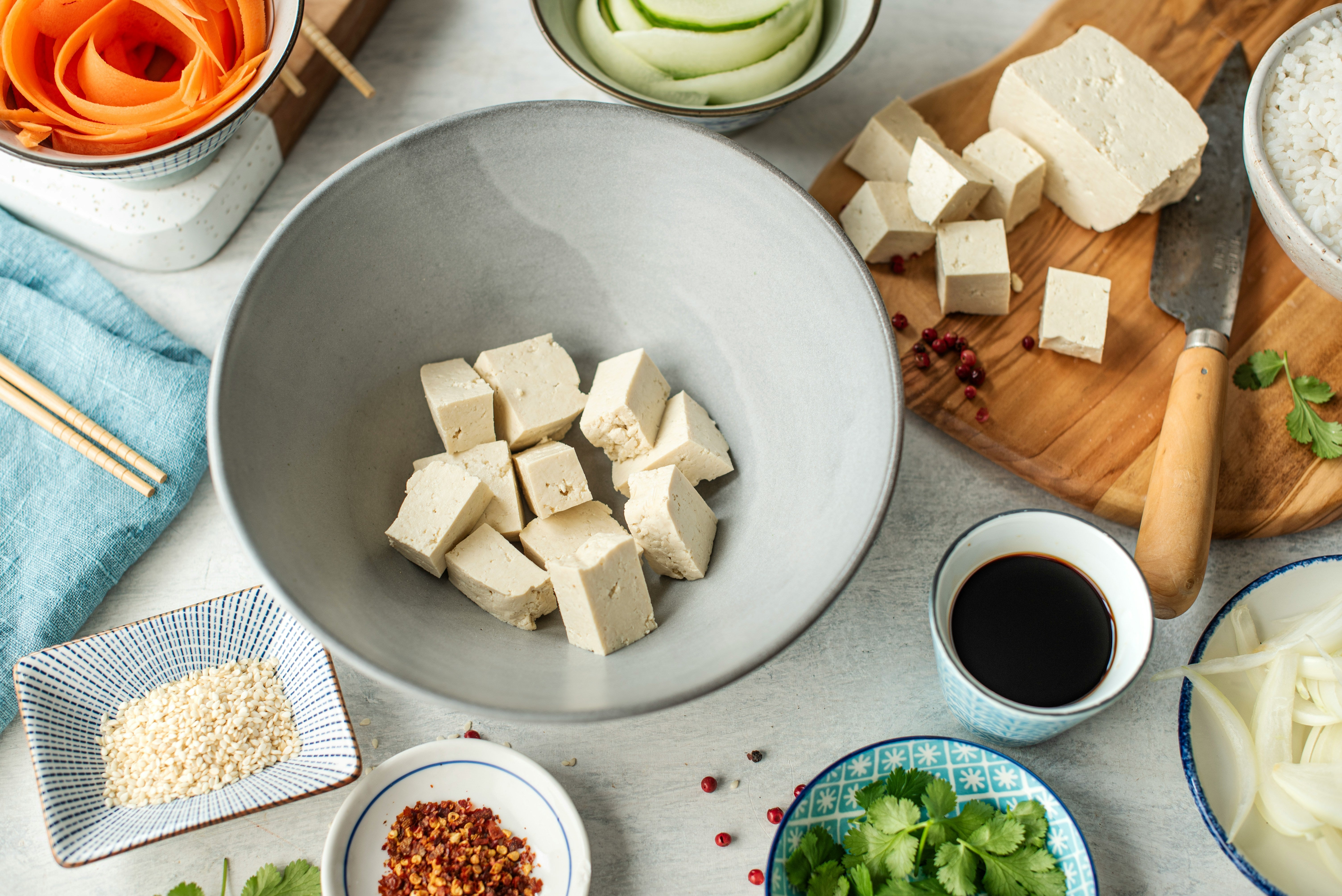 A table set with bowls of food, including tofu, a versatile and protein-rich ingredient ideal for creating egg-free meals for those with egg intolerance.