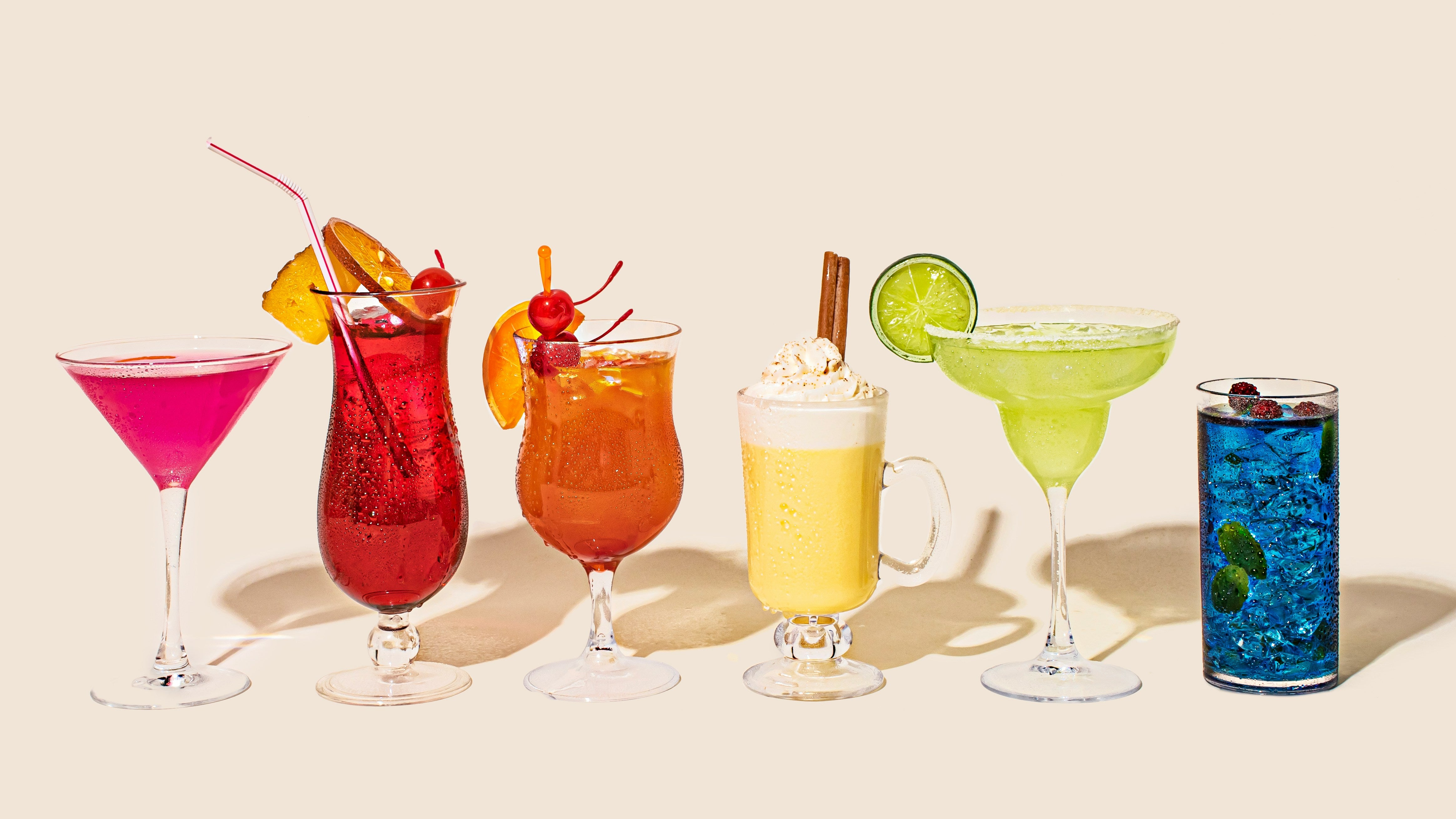 A group of colourful mixed drinks, illustrating beverages that may contain additives or sweeteners, which can exacerbate alcohol intolerance symptoms.