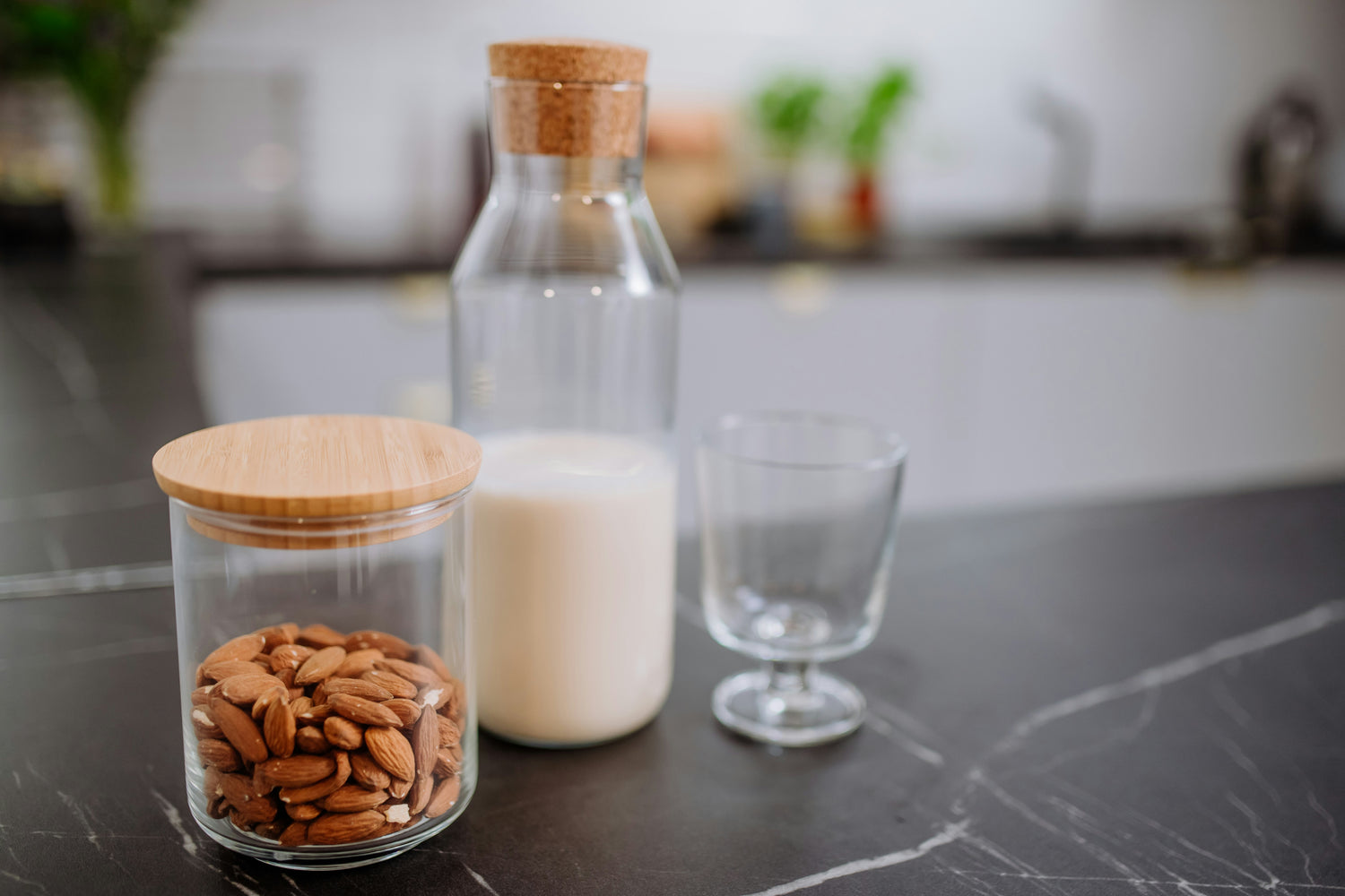 A bottle and glass of almond milk on a kitchen counter, a popular lactose-free alternative for those managing intolerance.