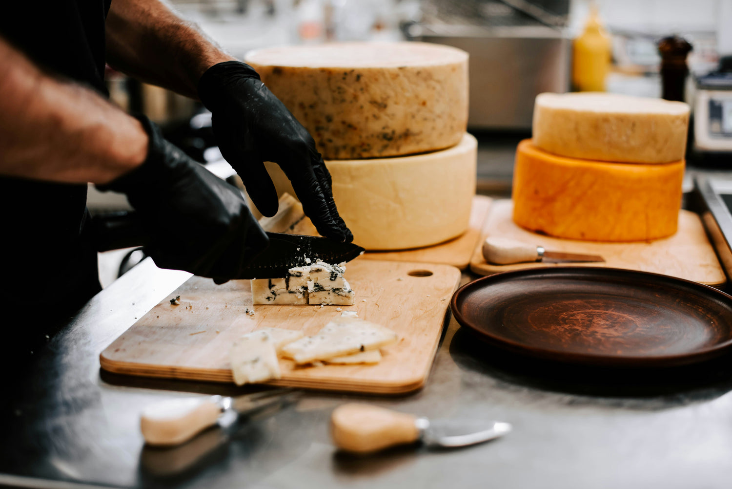 A person cutting cheese on a wooden board, showcasing a dairy product with varying lactose levels, often easier to digest when aged.