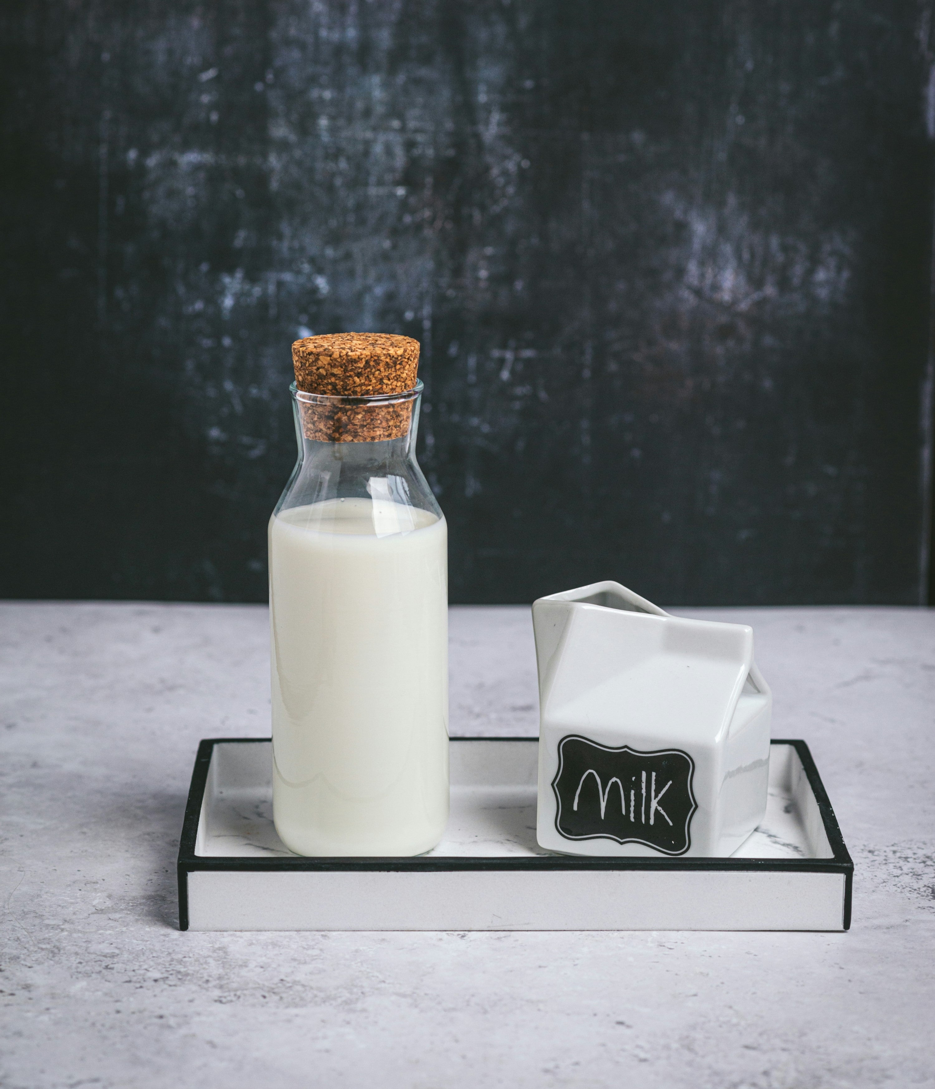 A bottle and glass of milk on a tray, underscoring the importance of checking labels and ingredients for hidden sources of lactose.