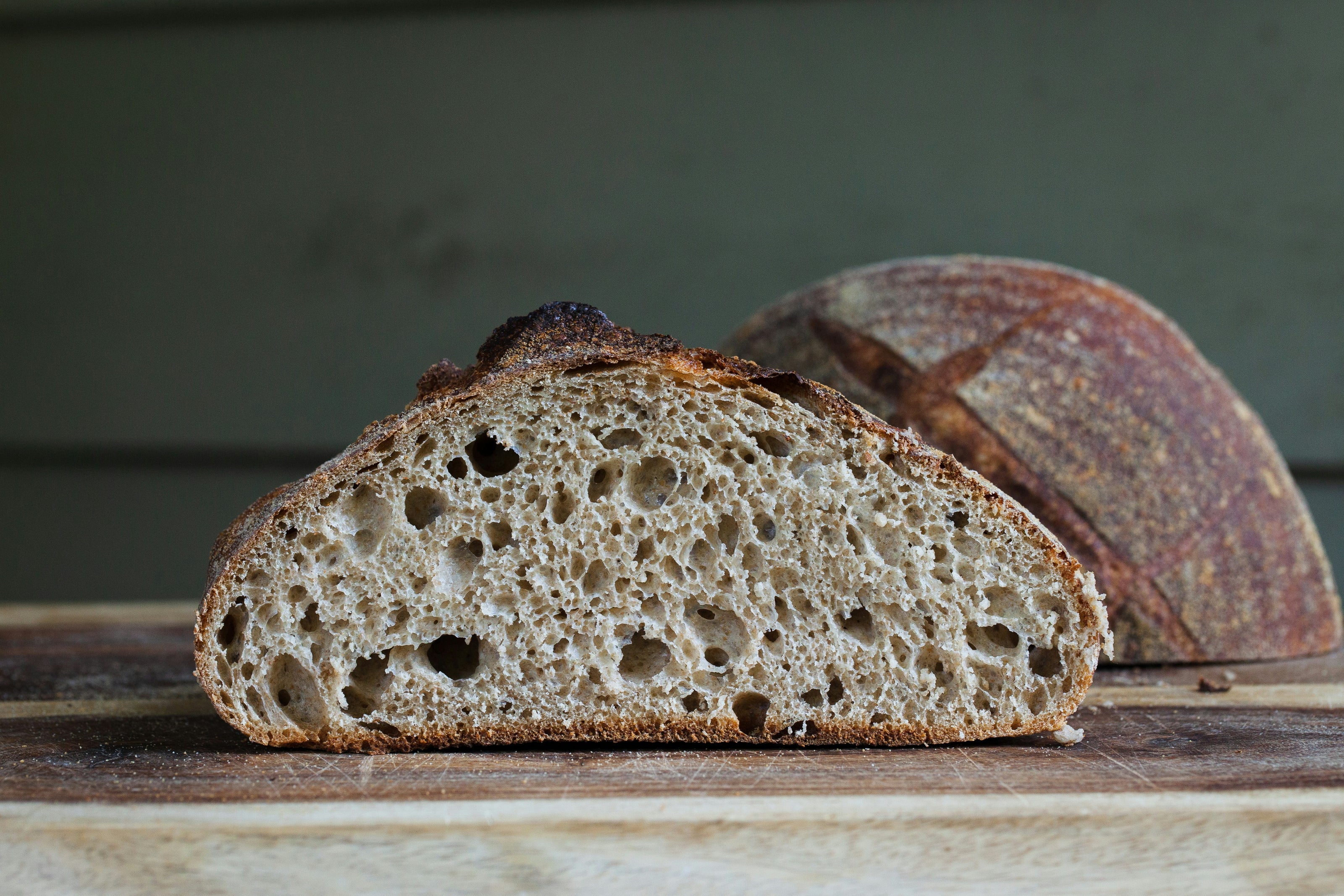 A loaf of brown bread on a white table, representing a common source of gluten that can trigger symptoms in individuals with gluten intolerance.